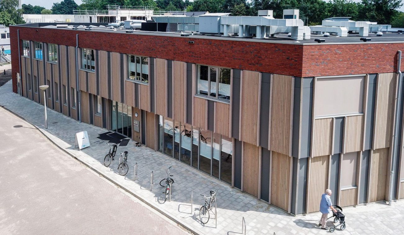 Voorzijde van het nieuwbouwproject met het GZC en de zorgwoningen, met zicht op de entree en moderne gevel.