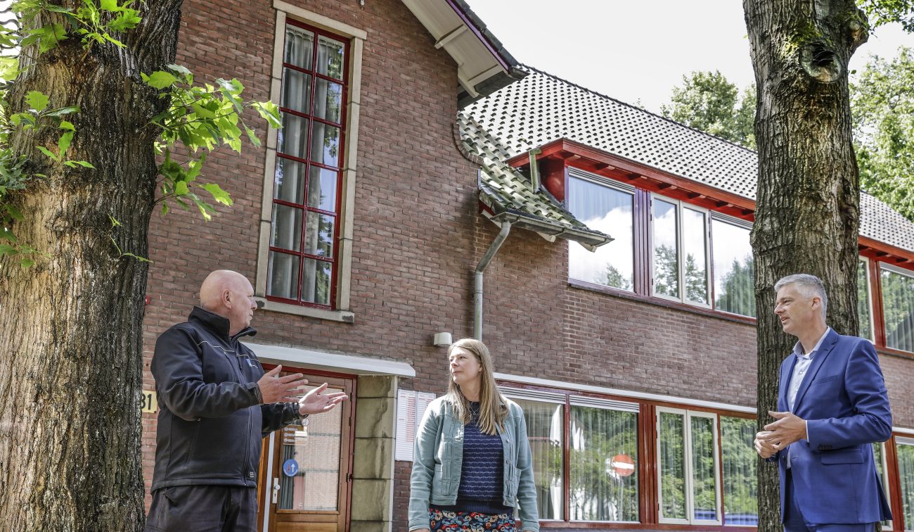 Renovatie Huis ter Heide: bakstenen paviljoen met rode kozijnen, dakpannen en overleg op de stoep