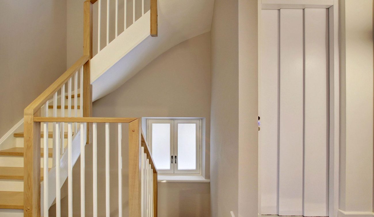 Interieurtransformatie Amsterdam: minimalistische trappenhuis met hout, wit en natuurlijk licht
