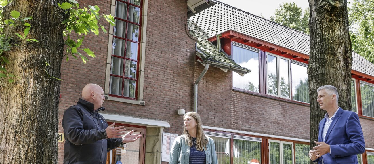 Renovatie Huis ter Heide: bakstenen paviljoen met rode kozijnen, dakpannen en overleg op de stoep