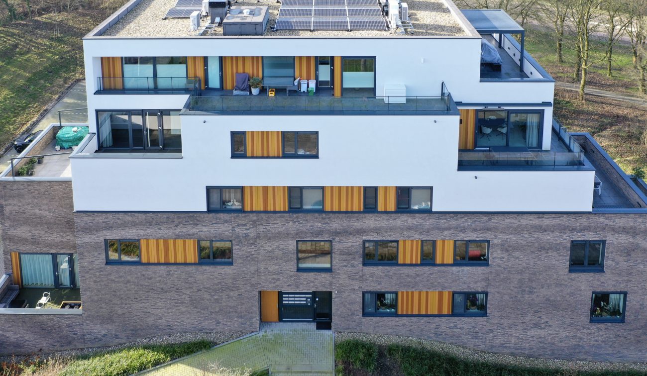 Moderne terrasappartementen met grote schuifpuien, balkons en verticale houten accenten — Gebiedsontwikkeling Parkheuvel Heerlen