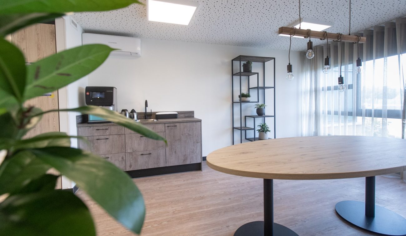 Interieur Aan de Bleek Schinveld: pantry met koffiemachine, ronde tafel, gordijnen en kamerplanten