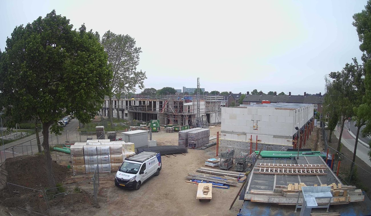 Nieuwbouw Emmalaan Roermond – bouwplaats met rijwoningen in kalkzandsteen/bloc in opbouw, steigers en bouwmateriaal; bestelbus op terrein