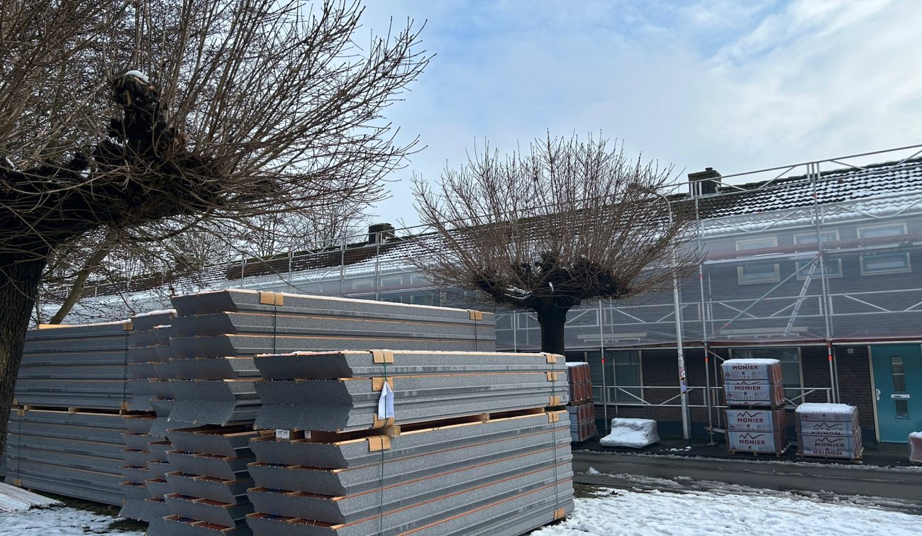 Groot onderhoud Berkdijk Tilburg: steigers bij rijhuizen, stapels dakplaten, sneeuwdek en knotbomen.