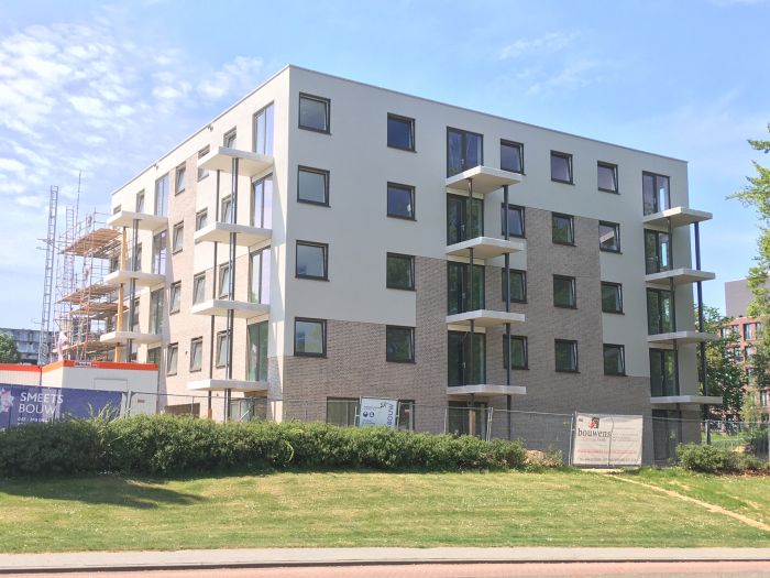 Nieuwbouw Noorderkroon Brunssum – vijflaagse appartementen met lichte gevel en baksteen, uitkragende balkons en bouwsteiger links