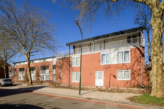 Vooraanzicht van wooncomplet met aanbouw van extra studio's op de bovenste verdieping