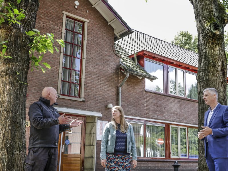Renovatie Huis ter Heide: bakstenen paviljoen met rode kozijnen, dakpannen en overleg op de stoep